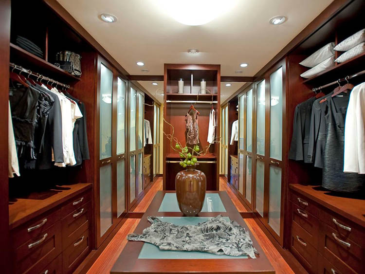 Lifetime Luxury - Luxury Closet Ideas096 - symmetrical wallnut wooden closet arranged on two sides with clothe racks first over a cabinet with drawers and wall wardrobes last. Big Chinese amphora in the middle -